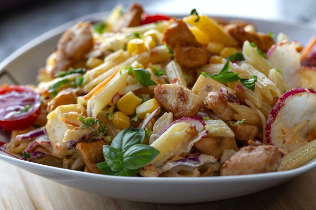 Fresh salad with grilled chicken meat and pasta