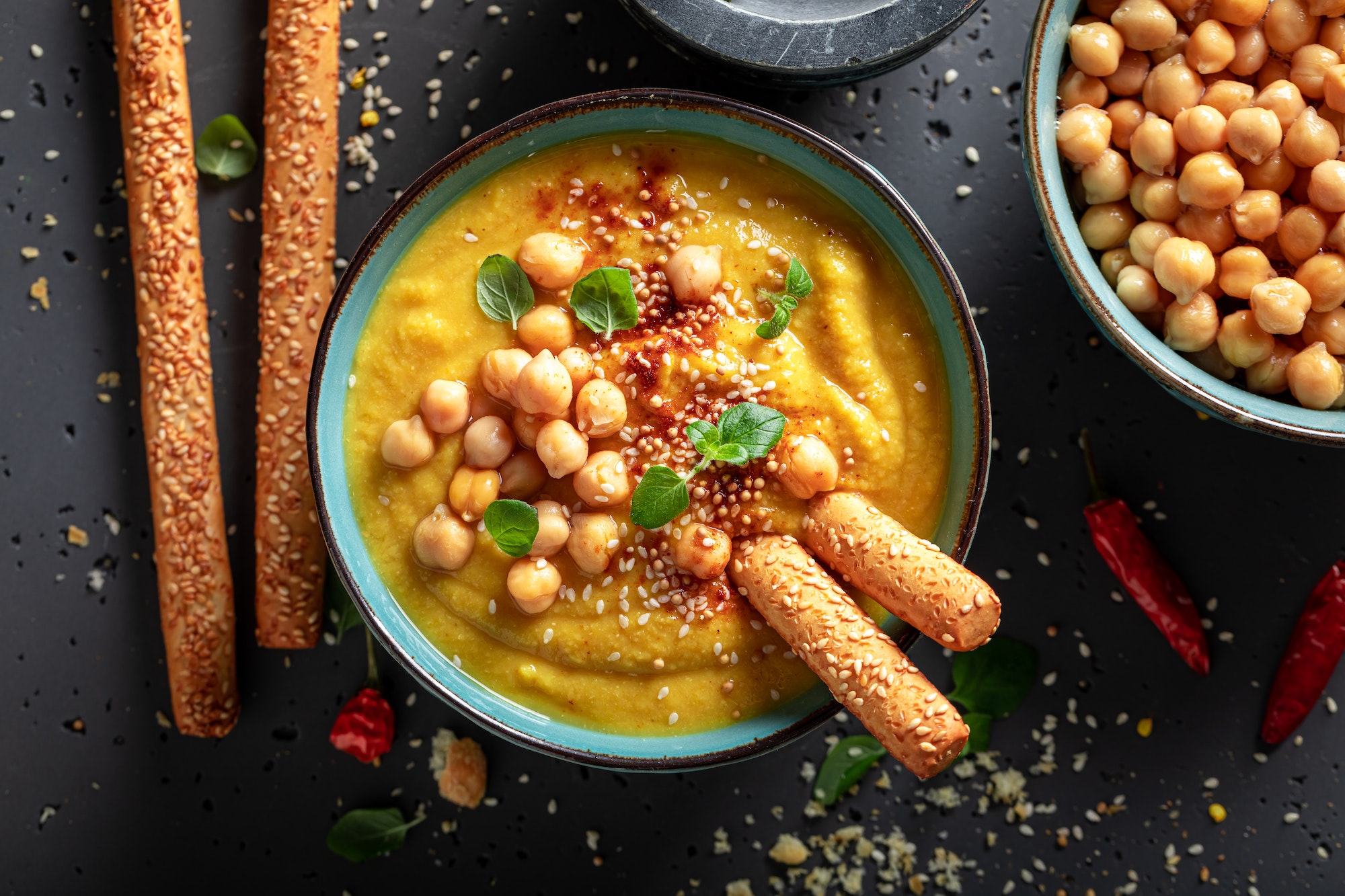 Healthy chickpea soup with grissini and sesame seeds.